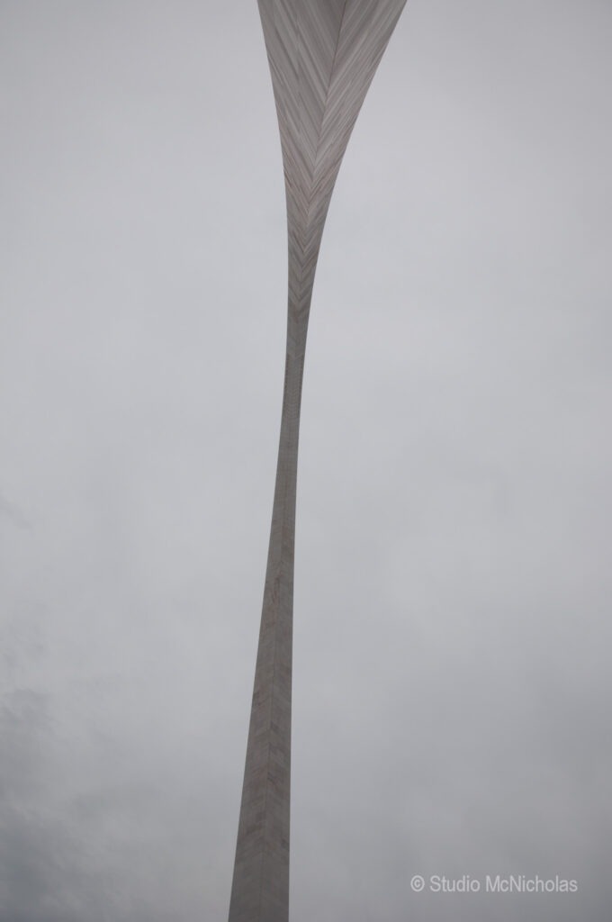 A soaring, sleek monument rises against a cloudy sky, showcasing modern architectural design and symbolizing ambition or progress.