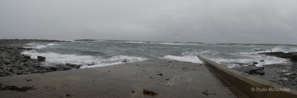 Stormy seascape featuring turbulent waves crashing against rocky shores and a concrete jetty, illustrating the power of nature.